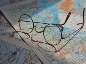 Sorgfältige Planung einer Reise mit Mietwagen anhand einer Landkarte und Brille